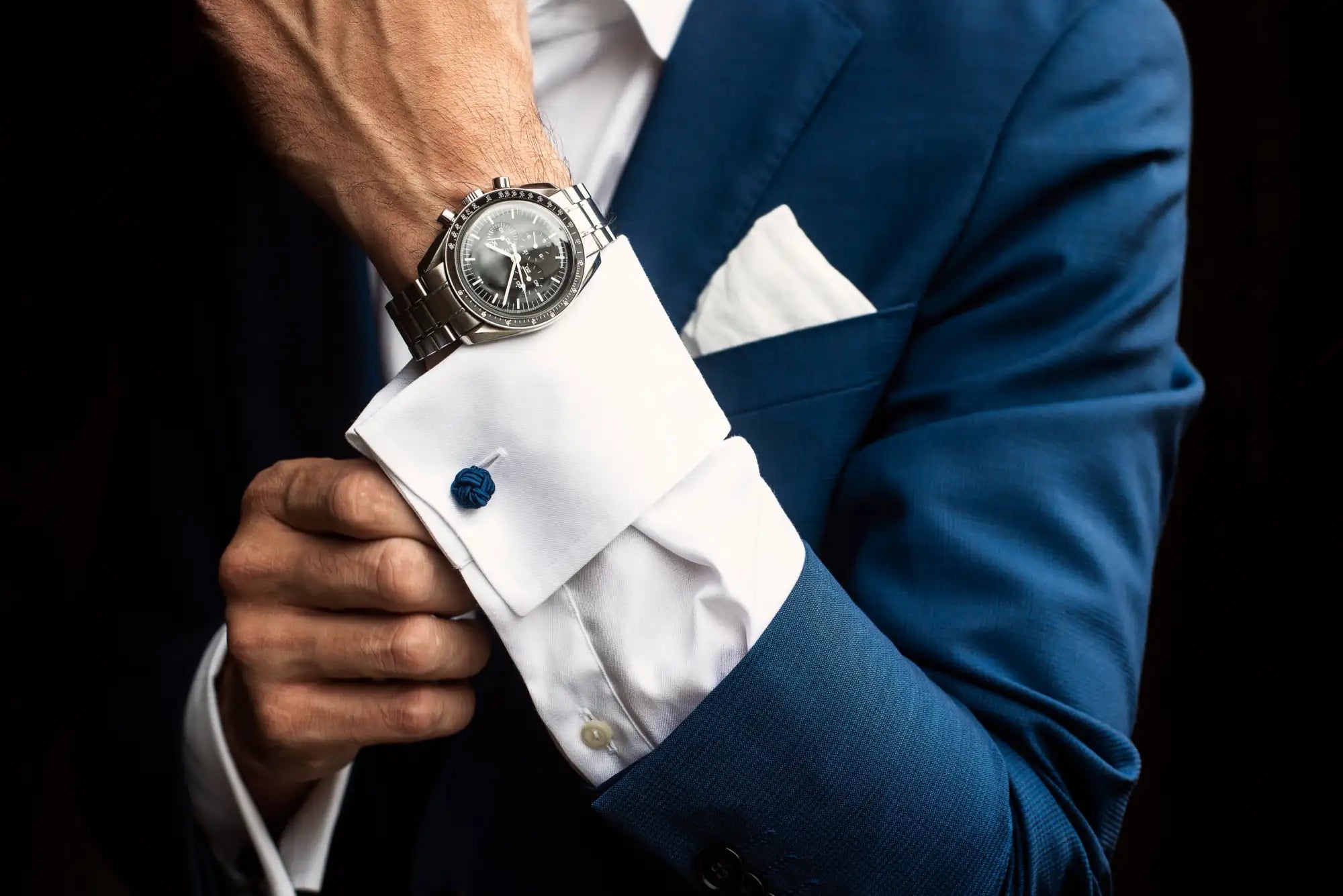 A sleek silver-toned omega speedmaster professional chronograph watch with a black dial and stainless steel bracelet, worn on a man’s wrist.